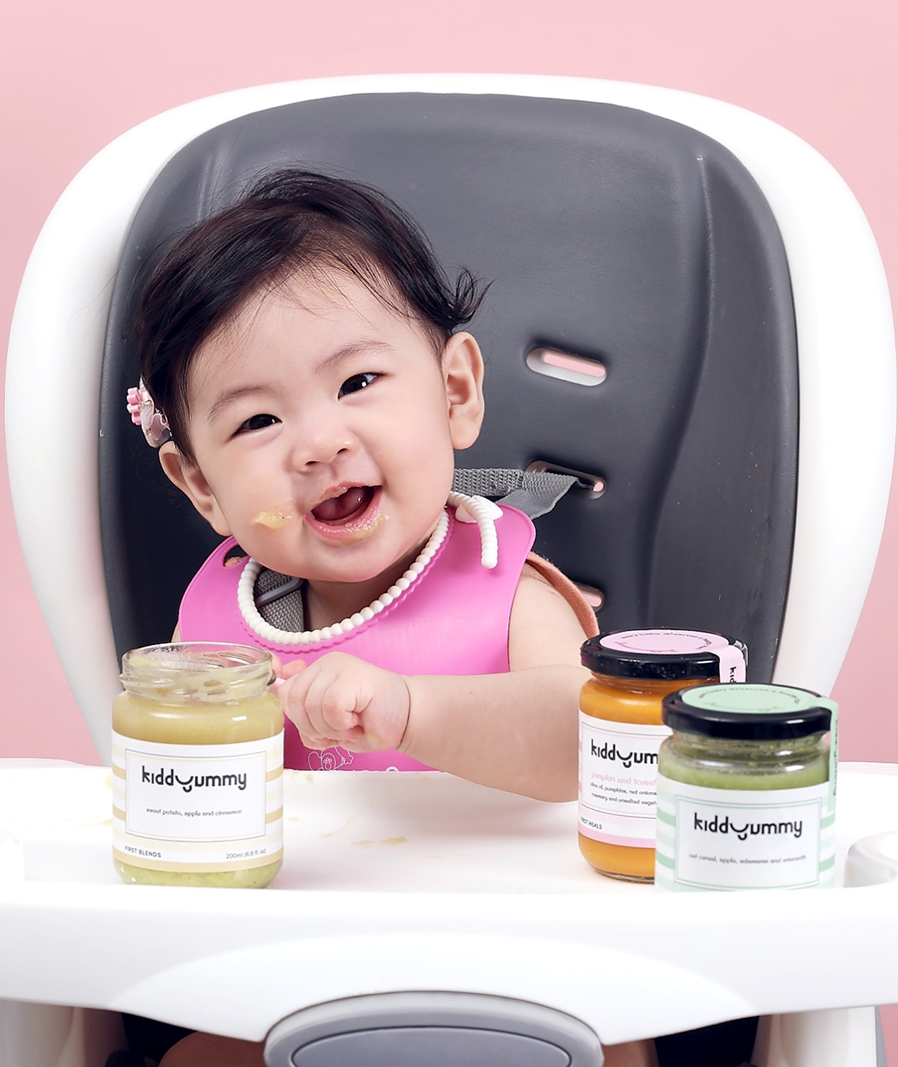 Asian baby girl sitting on chair having Kiddyummy meal