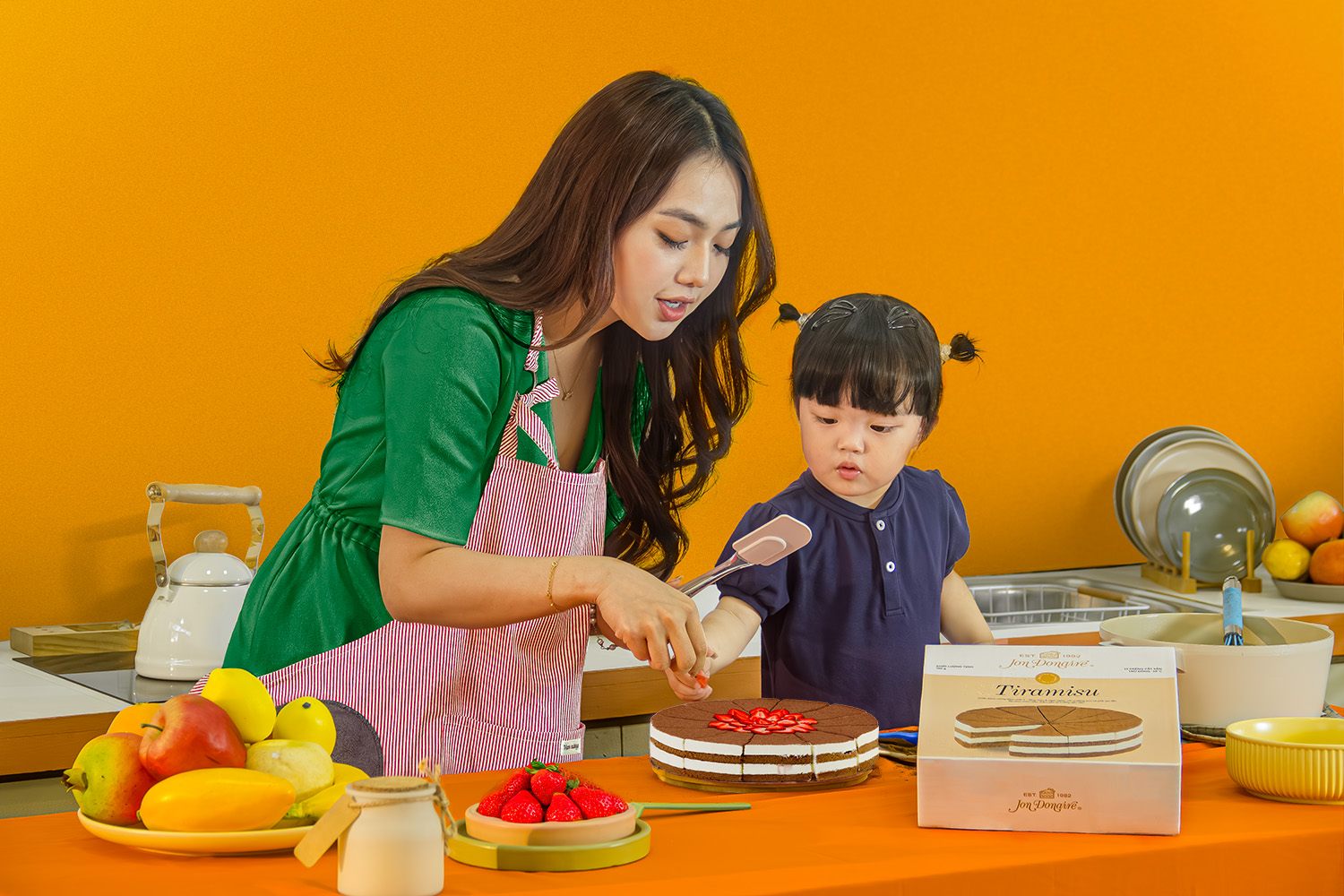 Mother and kid decorate Jon Donaire frozen cake by Rich Products